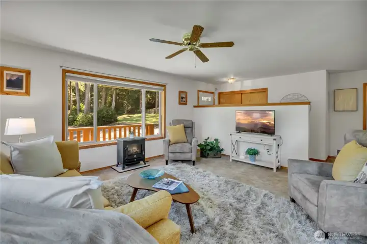 Living Room features a large bay window, multiple windows, designer appeal, ceiling fan and open concept living