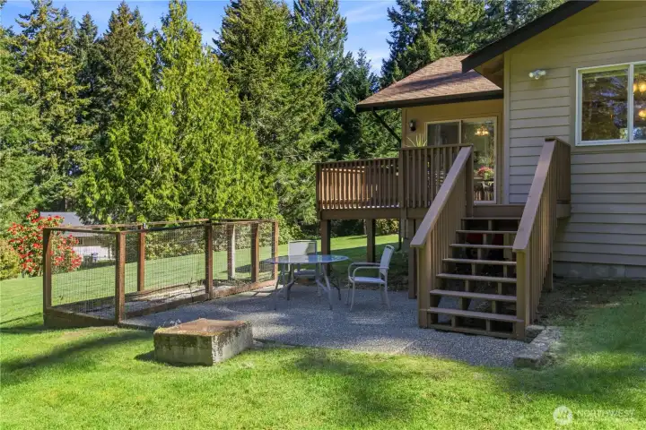 Deck extends to lower patio with fire pit and backyard lawn areas