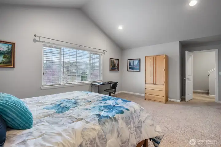 Dramatic vaulted ceilings elevate the already generous primary bedroom into something truly special