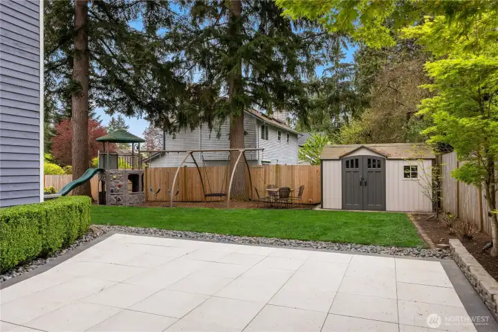Beyond the patio is a large level grassy area complete with a tool shed, swingset & slide!