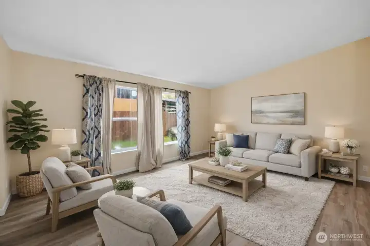 Bright living room with vaulted ceilings and abundant natural light. Virtually staged.