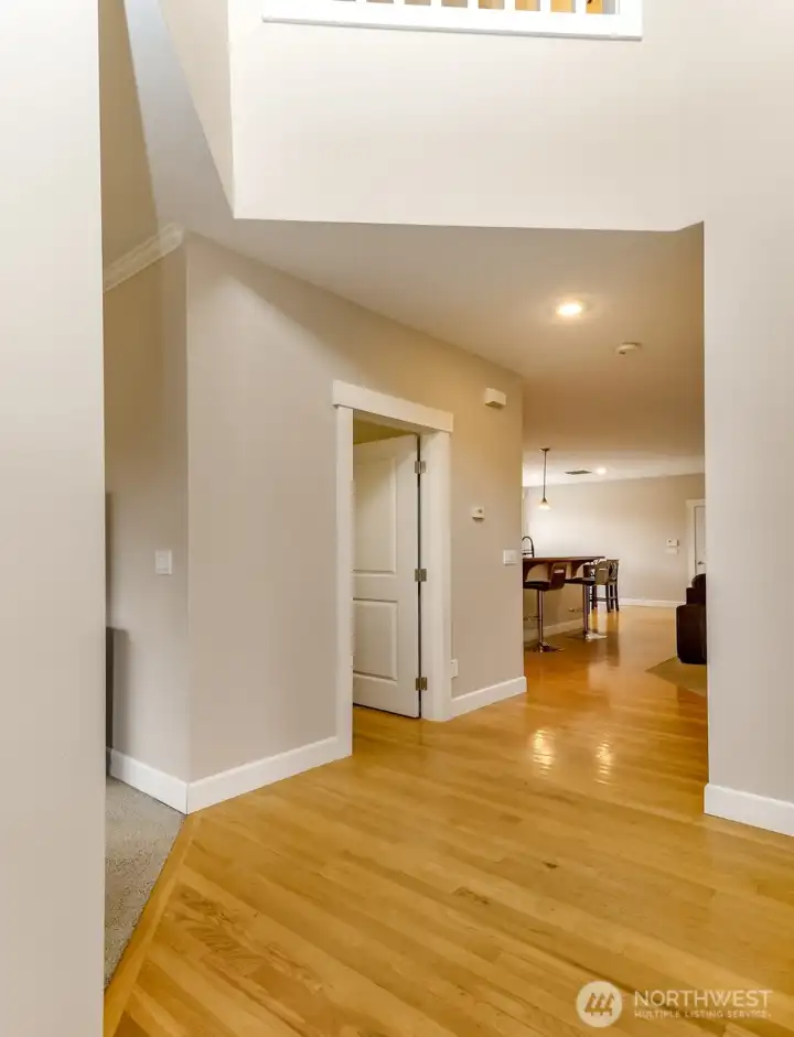 Solid hard wood floors lead to kitchen with a guest half bath tucked in between.