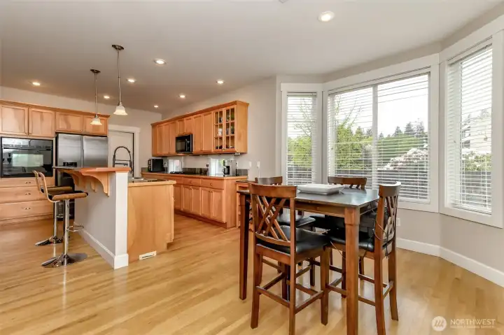 Hardwoods floors grace the kitchen with breakfast bar and extend into the open floor plan dining room.