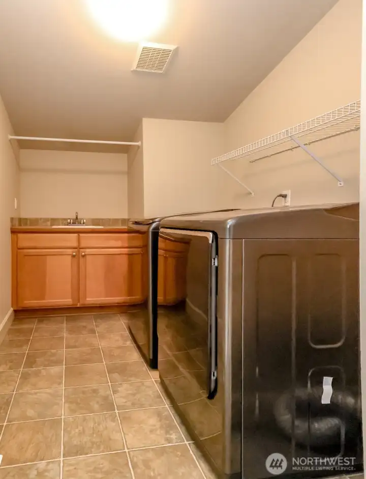 Upstairs laundry room with storage and a sink!