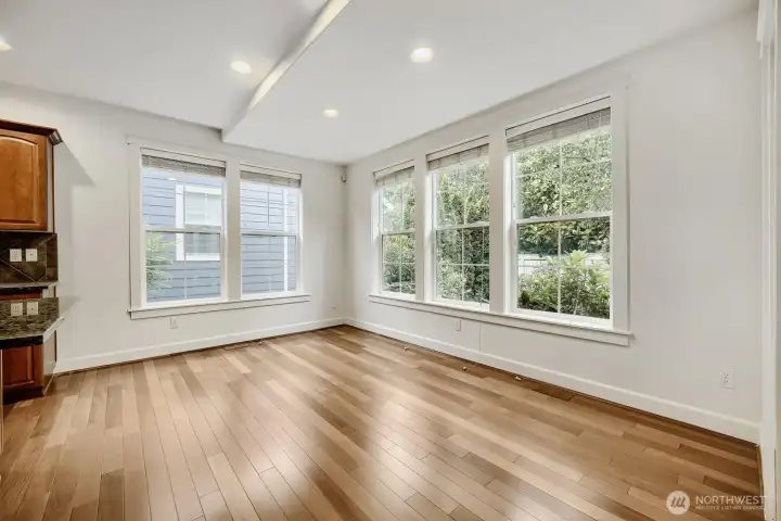Casual dining area framed by windows is open to both the kitchen and the family room.
