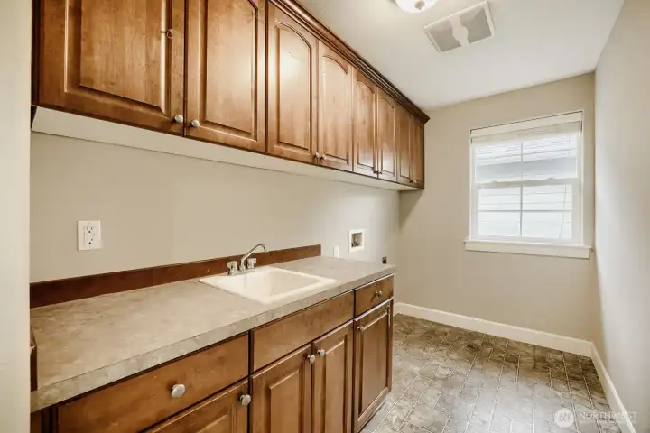 Laundry room with convenient sink and built-ins for added storage.