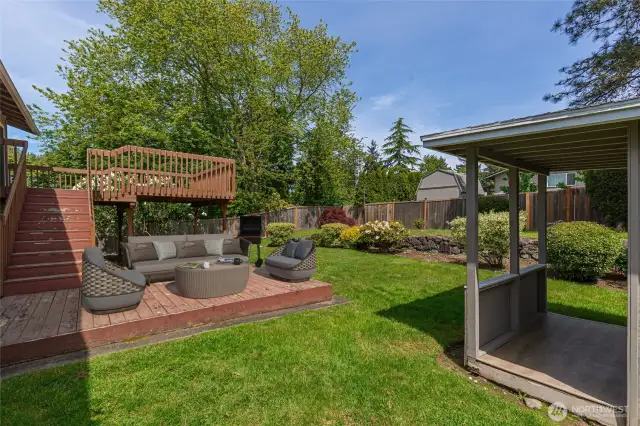 Expansive two-tiered deck overlooking backyard. Virtually staged.