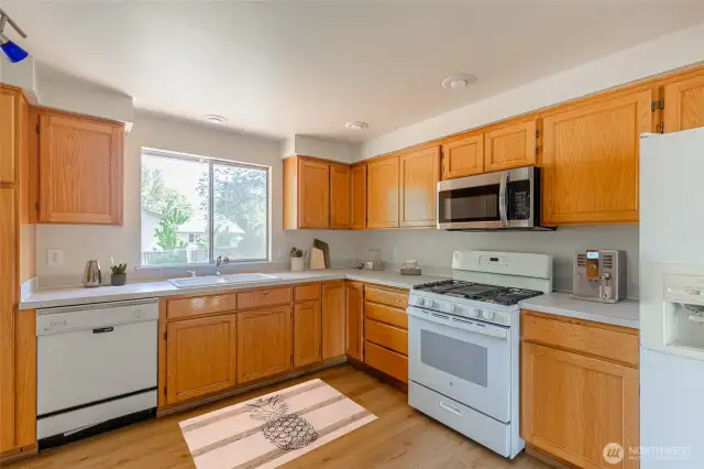 The spacious kitchen includes ample cabinetry. Virtually staged.