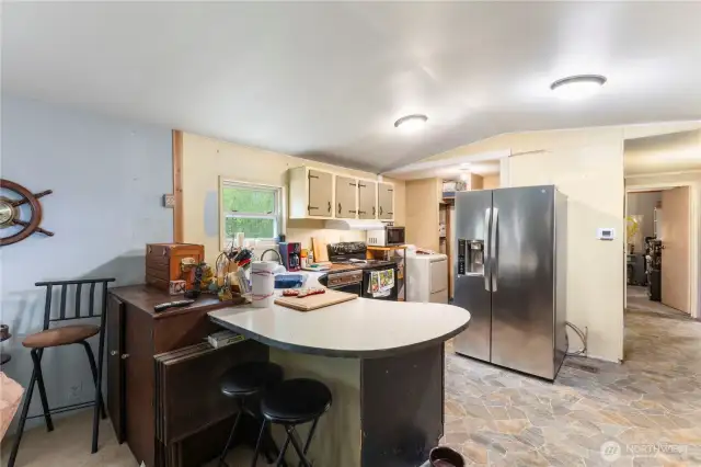 Large kitchen with pantry and breakfast bar.