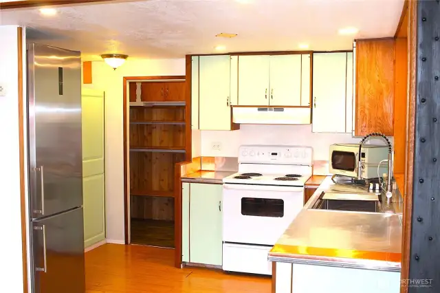 Kitchen with a door leading to the laundry/storage room.