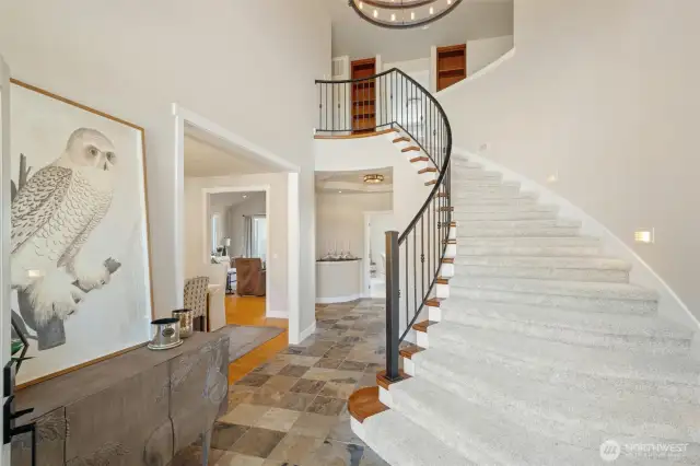 Grand entrance with dual staircases to upper level.