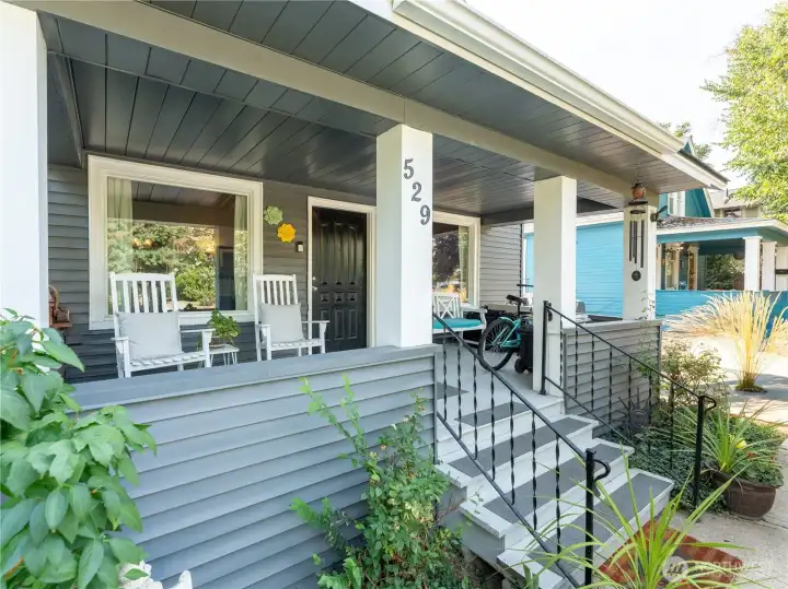 Large covered porch creates an inviting outdoor living space ideal for relaxing or entertaining guests.