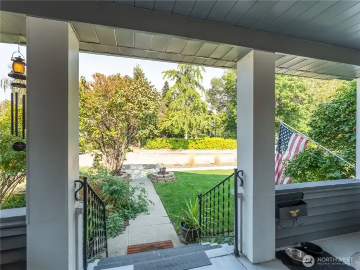 Welcoming covered porch blends historic Tudor charm with functional outdoor living space.