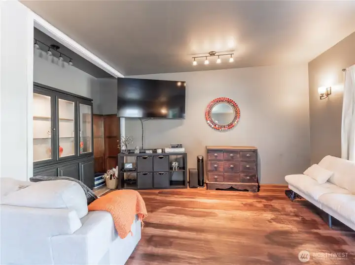 spacious living room with natural gas fireplace, original hardwood floors, and original Tudor charm.