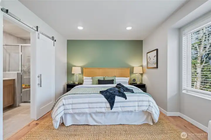 Primary suite with large bath finished with tile floor and tile shower surround from floor to ceiling. Dual sinks and quartz counters! Photos are of model home in the community.