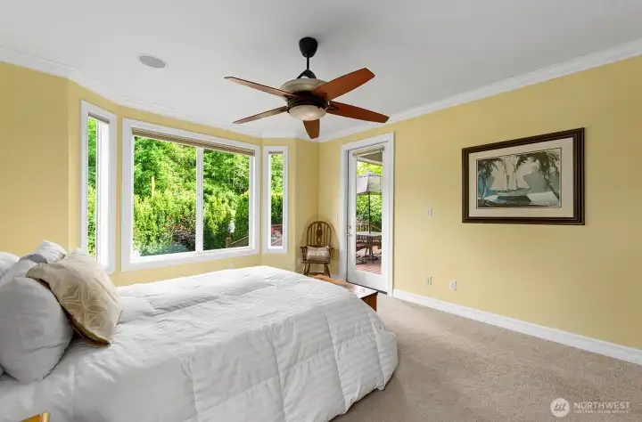 Primary Bedroom with large picture windows and glass door for Deck & Patio access.
