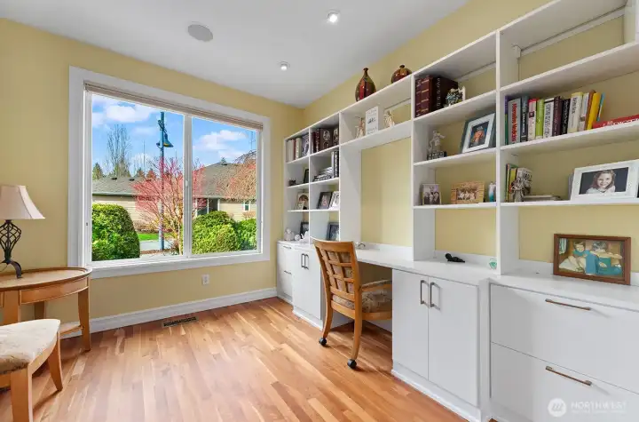 Spacious Den/Office is bright and features glass-panel French Doors plus custom built-ins and work station.