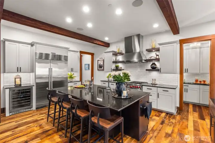 Featuring a Wolf 48" 6-burner gas range with griddle, dual ovens and matching vent hood, a Sub-Zero 48" refrigerator/freezer, Pental quartz countertops, and a classic white tile backsplash and two undercounter wine and beverage refrigerators. Abundant storage in the oversized pantry behind the range wall with 168 bottle Transtherm wine storage. Featuring a Wolf 48" 6-burner gas range with griddle, dual ovens and matching vent hood, a Sub-Zero 48" refrigerator/freezer, Pental quartz countertops, and a classic white tile backsplash and two undercounter wine and beverage refrigerators. Abundant storage in the oversized pantry behind the range wall with 168 bottle Transtherm wine storage.