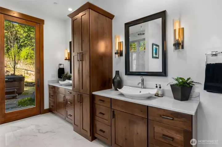 The primary ensuite features double sinks, Restoration Hardware metal mirrors and wall sconces, all beautifully finished with marble-look porcelain tile, an extra-large linen closet, and a private door leading to the Jacuzzi hot tub. The primary ensuite features double sinks, Restoration Hardware metal mirrors and wall sconces, all beautifully finished with marble-look porcelain tile, an extra-large linen closet, and a private door leading to the Jacuzzi hot tub.