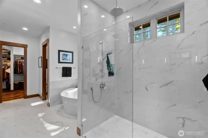 Beautiful ADA walk-in shower with wall-mounted and rain heads and the spacious walk-in closet impresses with a floor-to-ceiling custom system and cedar-lined drawers. Beautiful ADA walk-in shower with wall-mounted and rain heads and the spacious walk-in closet impresses with a floor-to-ceiling custom system and cedar-lined drawers.
