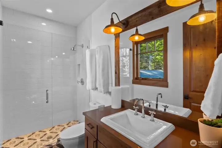 The second floor shared bath impresses with stunning decorative tile and a glass-enclosed shower. The second floor shared bath impresses with stunning decorative tile and a glass-enclosed shower.
