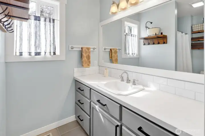 Relax in the primary bath featuring stylish tile flooring and a modern vanity.