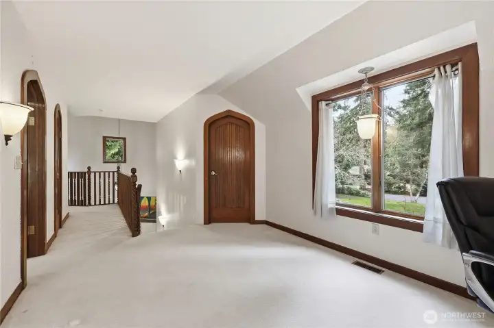 Upstairs hallway - middle door leads to a room with a window that currently has shelves for storage, but could easily be used as an office.