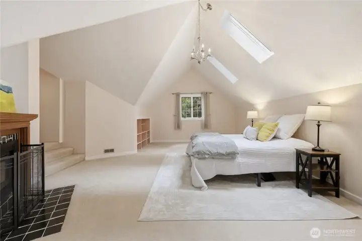 This large room can be used as the primary suite or play room or game room. It's staged as the primary suite with fireplace.