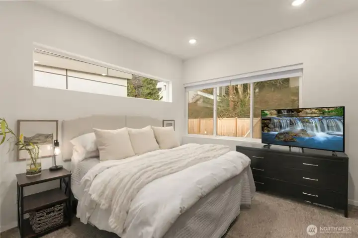 Primary bedroom with en-suite bath overlooking the private backyard