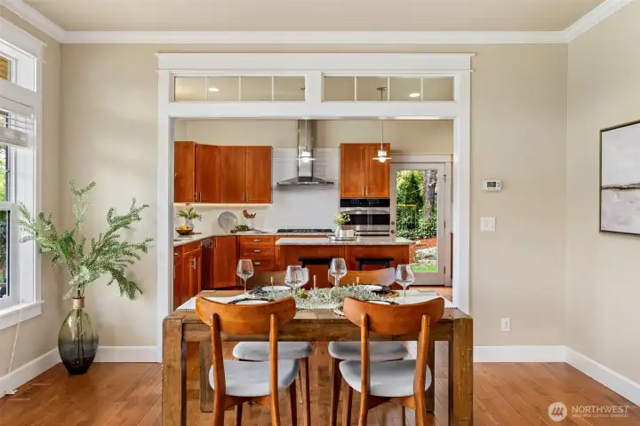 Dining room with gables that lead into chefs kitchen filled. Dining room is filled with natural light from panoramic windows and French doors that lead out to covered porch.