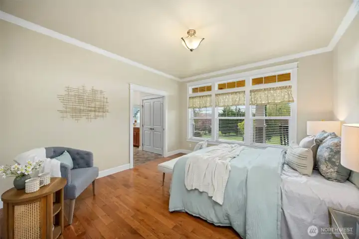 Primary bedroom featuring a walk-in closet, private ensuite, and large windows that fill the room with natural light.
