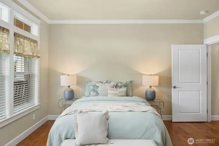 Primary bedroom featuring a walk-in closet, private ensuite, and large windows that fill the room with natural light.