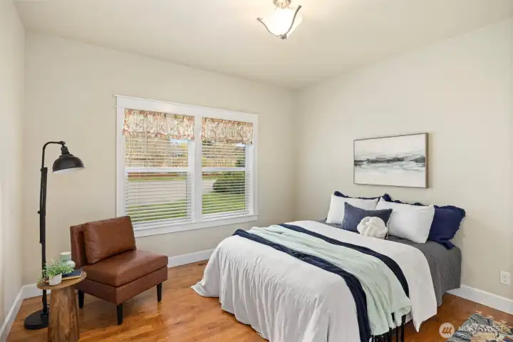 Secondary bedroom on main level with window looking out towards front driveway.