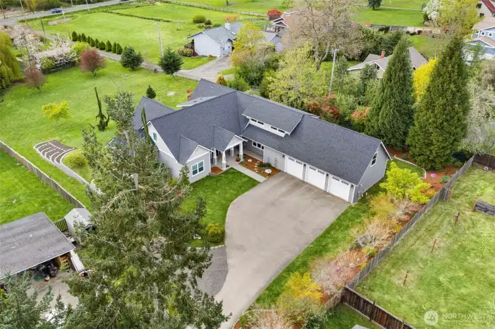 Aerial view of the home’s entryway. The yard is partially fenced, with markers in place so you can easily walk the property and get a sense of the lot’s size and space.