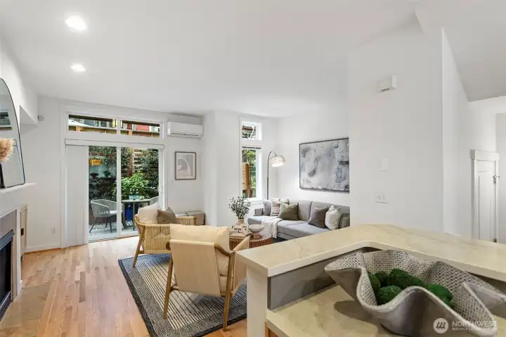 The living room connects to a private back patio area with mature beautiful landscaping.