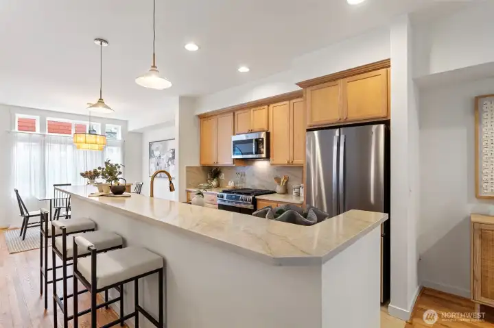 The kitchen has just been refreshed and boasts crushed quarts counters and backsplash, a new stainless undermount sink with pull down faucet and brand new GE Profile appliances including a gas range/oven.