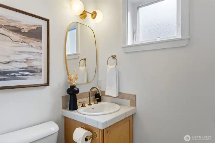 The main floor powder bath has just been refreshed with new hardware, faucet, mirror and lighting.