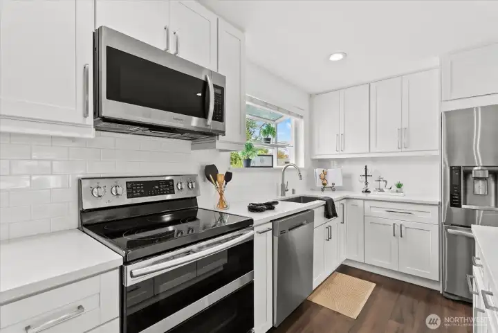 Stainless steel appliances and quartz countertops.