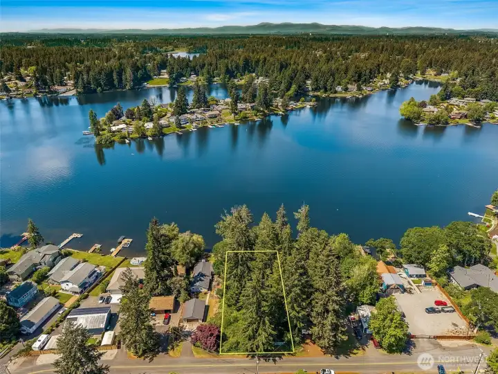 One of the LAST remaining vacant waterfront parcels on Long Lake! This .5432-acre rectangular lot delivers 110ft of swimmable waterfront with gorgeous southwestern exposure, meaning your future dream home gets the golden-hour evening light everybody wants! From this aerial perspective, you can really appreciate the setting with Holmes Island sitting directly across the water adding privacy and visual interest. Beyond that island sits Long Lake Park beach access, while the water glimmering further in the distance is Hicks Lake just beyond Carpenter Rd. Add nearby Pattison Lake and suddenly you are living in a full-blown lake lovers playground. Tucked within the Lacey Urban Growth Area, this property offers the rare combo of raw natural waterfront beauty plus close proximity to urban services, nearby sewer connection, public water nearby on lot side of street & easy access to shopping, dining and I-5. Dream house material with zero HOA drama attached.