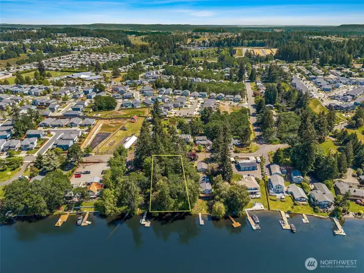 This north-facing aerial really drives home how perfectly positioned this property is between nature and convenience. Looking out beyond the lot, you can spot nearby Seven Oaks Elementary School, while further north the greenery stretching through the distance includes the beautiful Karen Fraser Woodland Trail and surrounding Woodland Creek Community Park area. Beyond that sits the Regional Athletic Complex, and then suddenly you are right into the massive convenience hub surrounding Hawks Prairie with shopping, restaurants, coffee, groceries, services and Costco all within easy reach. Even I-5 access is less than 10 minutes away, which means this property somehow manages to feel hidden away in a forested lake setting while still keeping you incredibly connected to daily life.