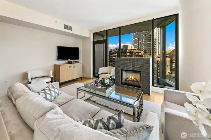 Cozy gas fireplace anchors the living room, but does not distract from the floor to ceiling window wall views.