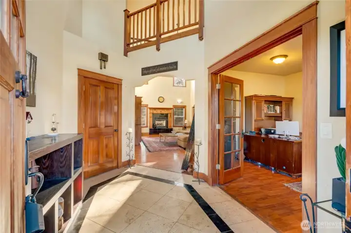 This gorgeous entry way features travertine and marble flooring and an adjacent office space with french doors.
