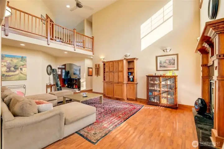 Another view of the living room and open hallway above with the entry way in the background.
