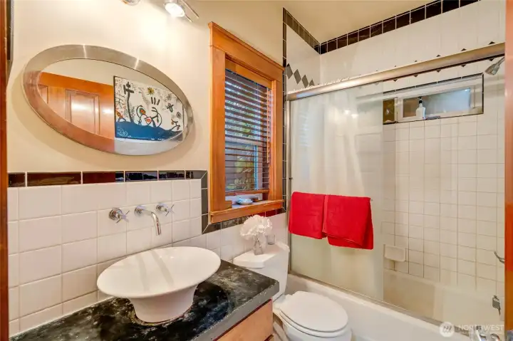 First floor full bath with ceramic tile tub enclosure and wainscot wall.