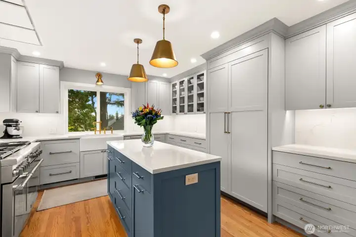 A stunning kitchen featuring custom cabinetry, stainless steel appliances, quartz countertops, and a charming built-in bench seating dining nook.