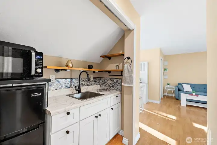 Secondary living space is equipped with kitchen prep area and secondary laundry unit.