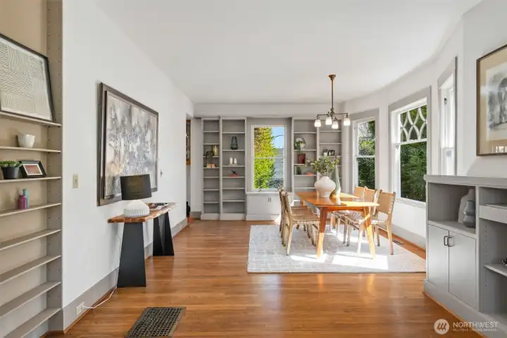 Period windows pour-in southern light, notice all  the built-in bookshelves in both living & dining room areas