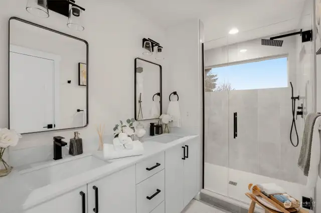 Accompanying the primary bedroom is this luxurious spa-like bathroom - complete with dual vanity, under-sink storage, walk-in rain shower with hand nozzle and clerestory window for added natural light. Photos of model home with similar layout, fit & finishes