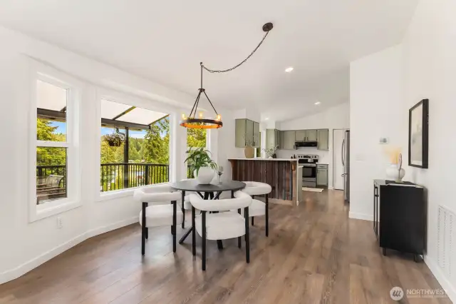 A designer light fixture anchors the dining space while walls of windows fill the room with natural light and lush greenery. The perfect blend of rustic and refined, ideal for intimate dinners or weekend brunches.
