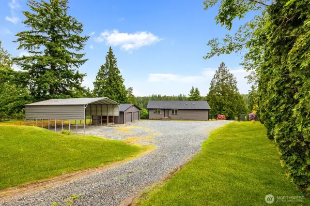 This oversized gravel driveway offers ease of access and ample parking, while the detached two-car garage and large carport provide perfect storage for your boat, RV, or weekend gear.